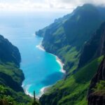 Lush green mountains meet the blue ocean.